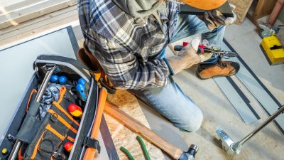 a-construction-worker-uses-a-toolbox-while-install-2025-03-15-18-44-58-utc.jpg